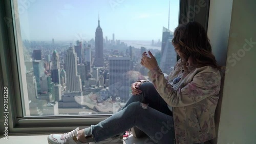 Girl looking from skyscraper at Manhattan city streets in New York