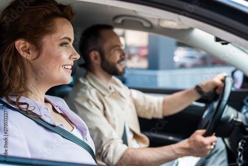 selective focus of happy woman sitting near handsome man driving car © LIGHTFIELD STUDIOS