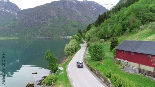 Car on driving road trip on picturesque Norwegian roads next to the fjord