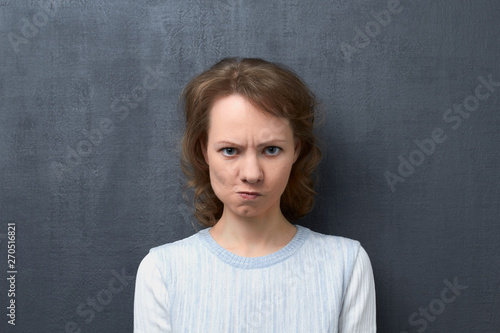Portrait of dissatisfied girl with frowning face