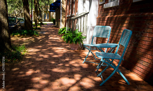Blue patio chairs on brick sidewalk photo