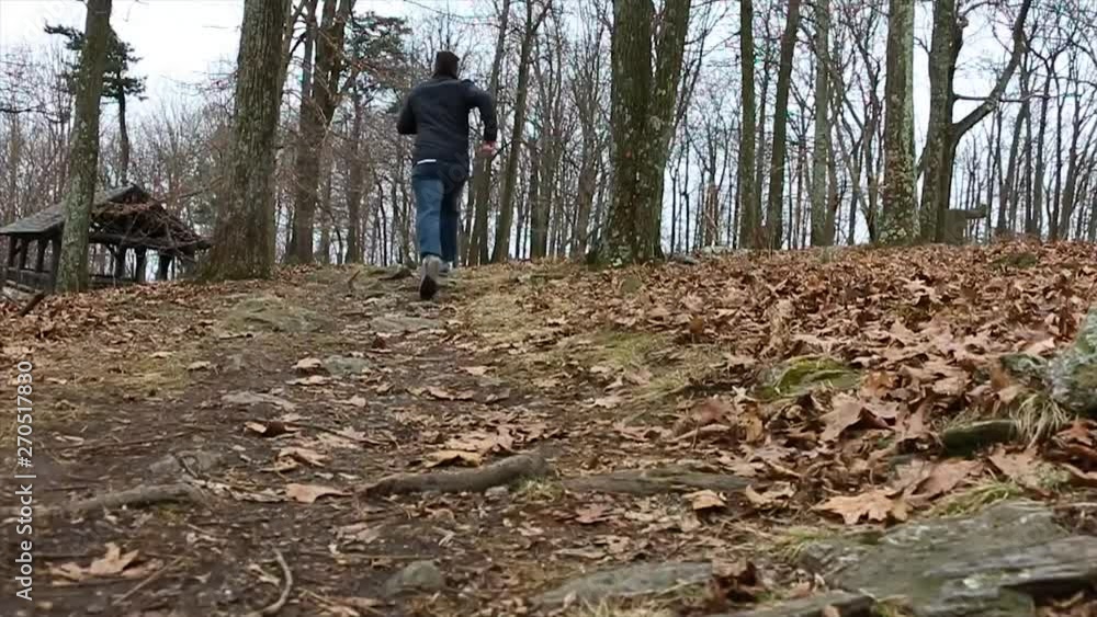 Man running through the woods in the fall. Man running through the woods in the fall.