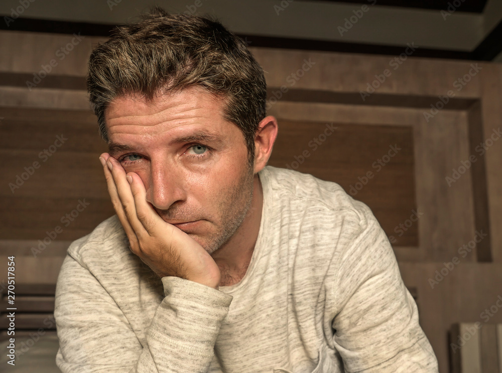 dramatic home portrait of 30s to 40s lost depressed and desperate man sitting on bed suffering anxiety crisis and depression problem crying sad and thoughtful dramatic home portrait of 30s to 40s lost depressed and desperate man sitting on bed suffering anxiety crisis and depression problem crying sad and thoughtful