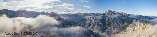 Great panoramic aerial landscape view of the snowy massive mountain in sunlight. Picturesque and gorgeous scene.