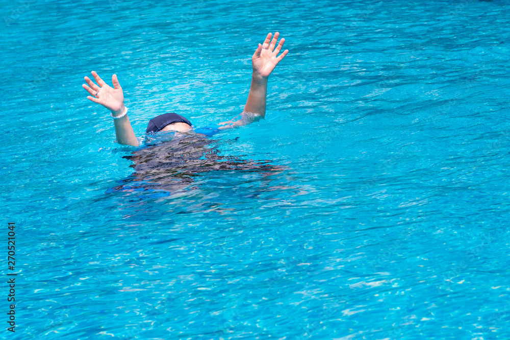 Woman are raising their hands for help, because they are weak, and is drowning while he swims in the pool, to sport and recreation concept.