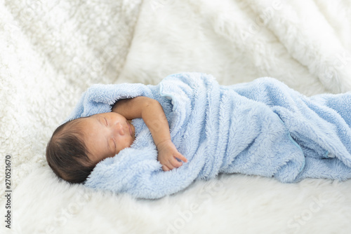 Newborn baby sleeping in bed