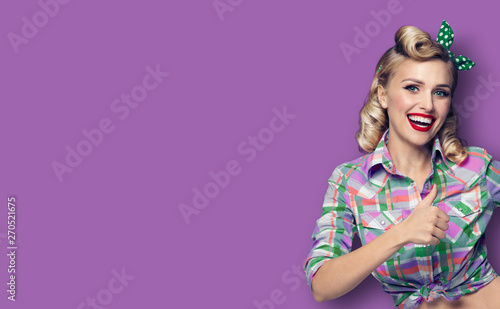 Photo of happy woman, showing thumb up gesture, in pin-up, over violet background