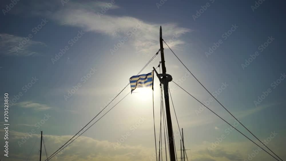 Greek National Flag on Boat Pole Waving Under Beautiful Sunset Backlight Greek National Flag on Boat Pole Waving Under Beautiful Sunset Backlight