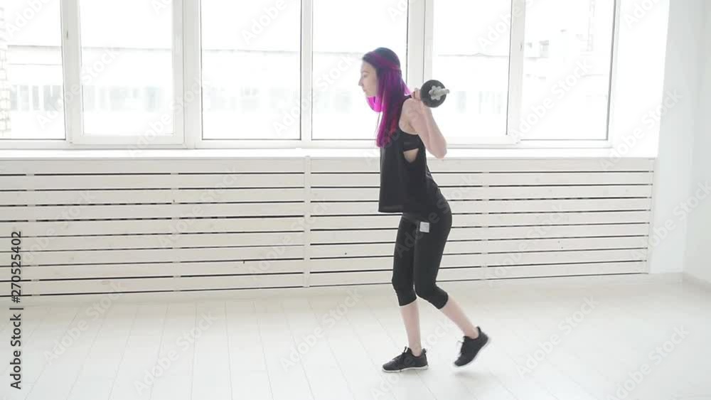 Concept of sport and fitness. Young woman barbell in the gym or home Concept of sport and fitness. Young woman barbell in the gym or home