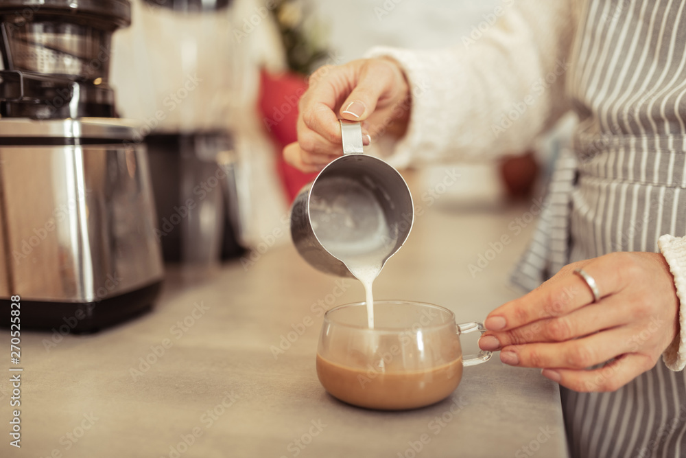Pouring some milk into freshly brewed coffee. Pouring some milk into freshly brewed coffee.