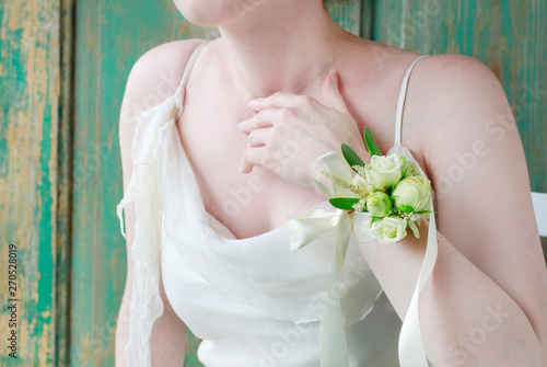 Vászonkép Bride wearing wrist corsage made of rose and eustoma flowers.