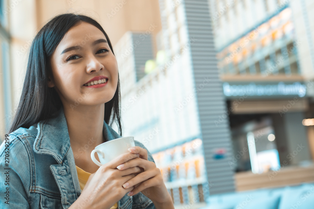 Asian woman in a cafe drinking coffee .Portrait of Asian woman smiling in coffee shop cafe vintage color tone. Asian woman in a cafe drinking coffee .Portrait of Asian woman smiling in coffee shop cafe vintage color tone.