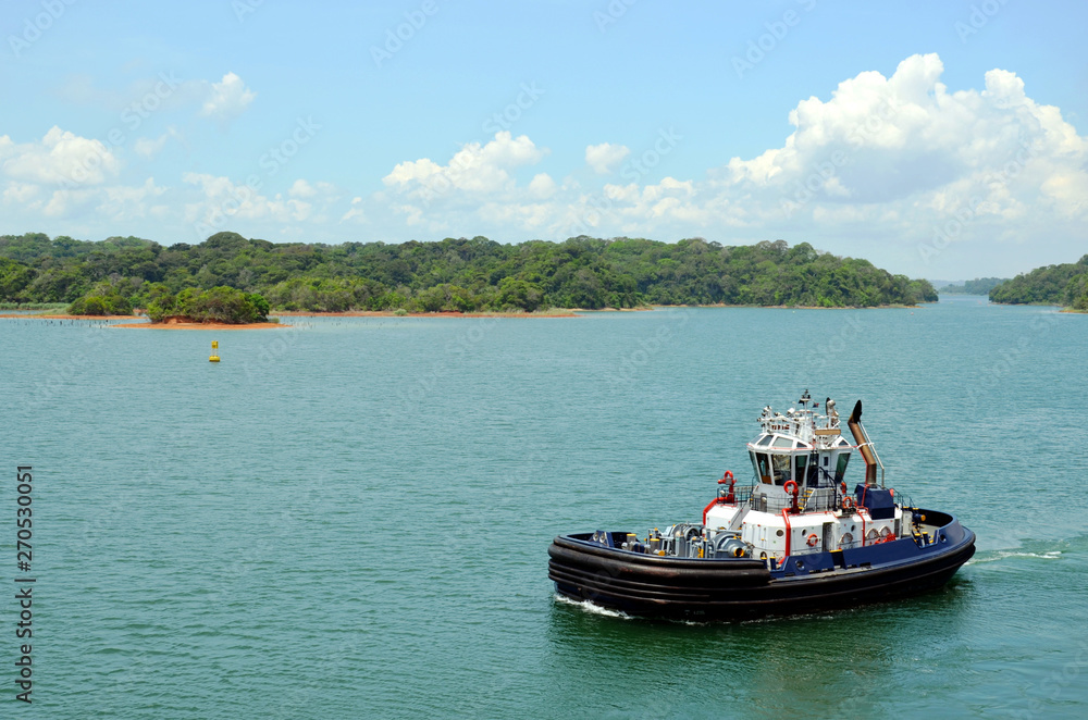 Panama Canal tug boats assisting to the transiting cargo ships.