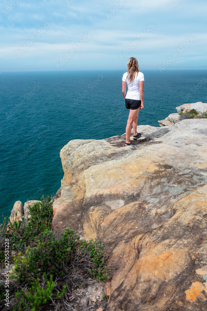 Woman gazing out from the cliff top views Royal National Park Woman gazing out from the cliff top views Royal National Park