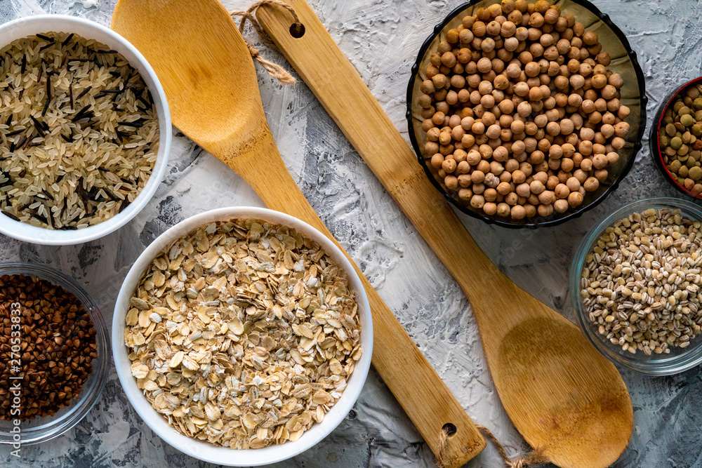 selection of raw uncooked cereals grains in bulbs with chickpeas oat lentil rice buckwheats selection of raw uncooked cereals grains in bulbs with chickpeas oat lentil rice buckwheats