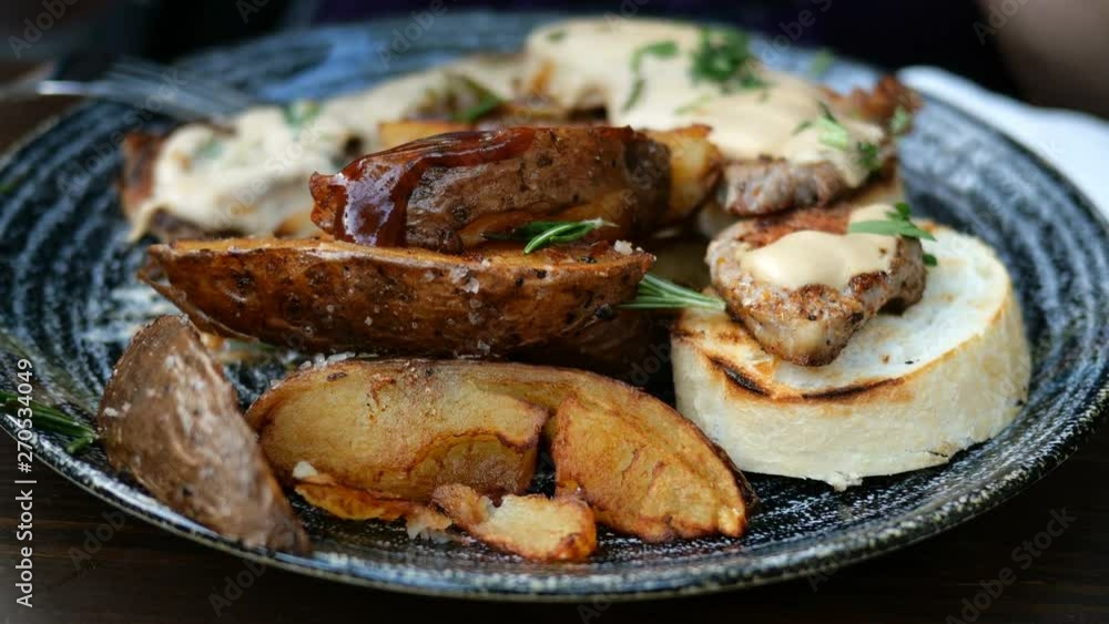 Fried potatoes with sauce and meat, pour the sauce on crockery in rustic style. Fried potatoes with sauce and meat, pour the sauce on crockery in rustic style.