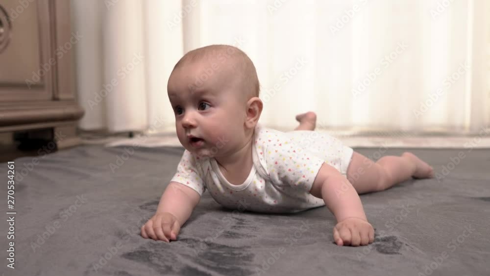 Childhood, babyhood and people concept - happy infant kid playing with colorful ball on the floor at home Childhood, babyhood and people concept - happy infant kid playing with colorful ball on the floor at home