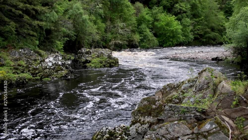 River pan/motion during mid spate through a gorge surrounded by lush new spring forest growth in May, Scotland. River pan/motion during mid spate through a gorge surrounded by lush new spring forest growth in May, Scotland.