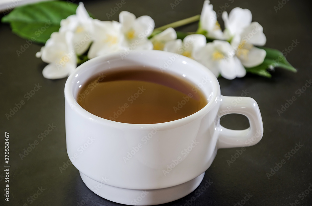 cup of tea with jasmine on a black background, close-up cup of tea with jasmine on a black background, close-up