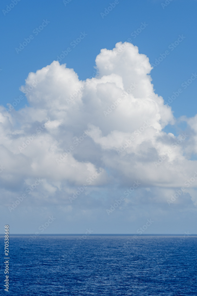 Blue sky with white clouds over the azure waters of the ocean.