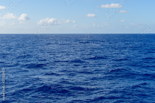 Blue sky with white clouds over the azure waters of the ocean.