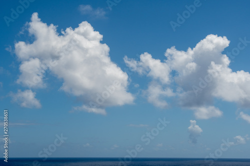 Blue sky with white clouds over the azure waters of the ocean.