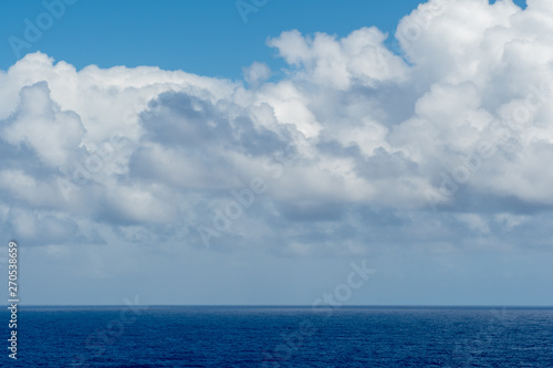 Blue sky with white clouds over the azure waters of the ocean.