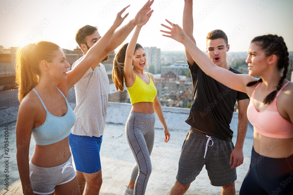 Group of young happy people friends exercising outdoors at sunset. Group of young happy people friends exercising outdoors at sunset.