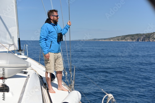 Man sailing with sails out on a sunny day