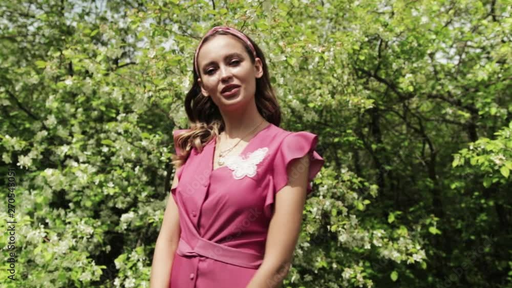 young girl in pink dress posing in front of blooming garden, blooming Apple trees, summer, spring, beautiful nature