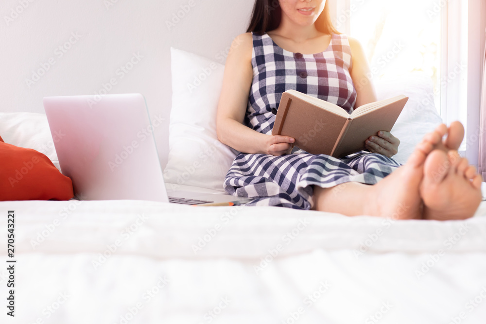 Asian Young beautiful pregnant woman sitting and reading a book in bedroom at home. Asian Young beautiful pregnant woman sitting and reading a book in bedroom at home.
