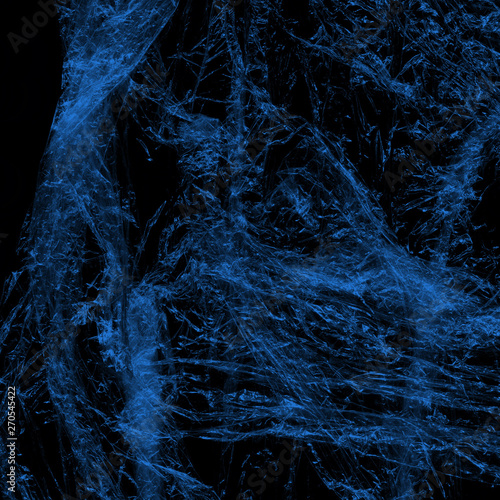 Transparent blue plastic wrap on the black background. Plastic shopping bag texture. Reusable trash and waste. © artistmef