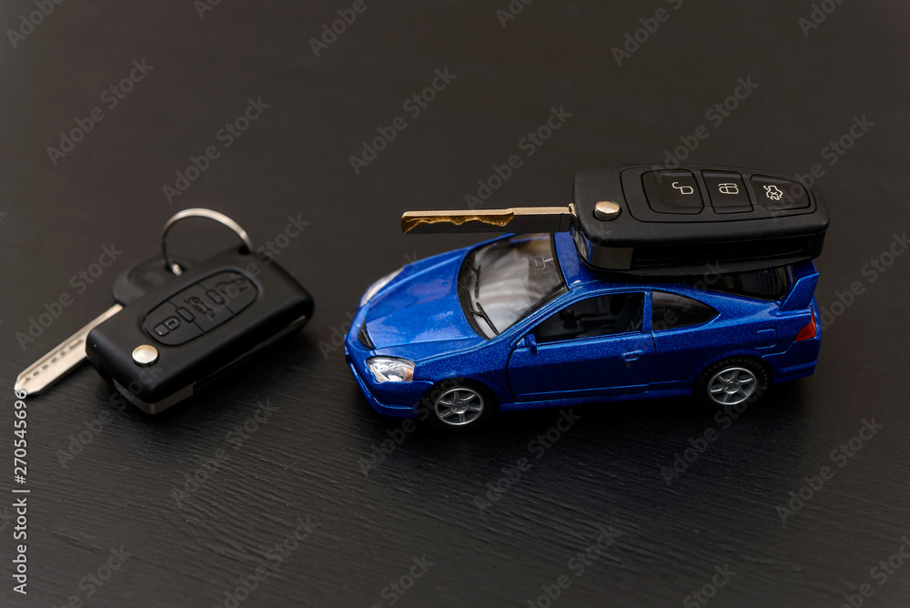 Blue toy car with keys on dark background Blue toy car with keys on dark background