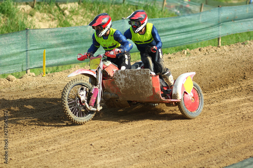 Sidecar motocross athletes on the dirt track 