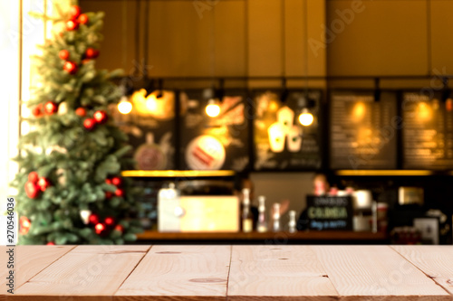 Empty wood table top with blurred chistmas holiday background with coffee shop (cafe) and restaurant shop.