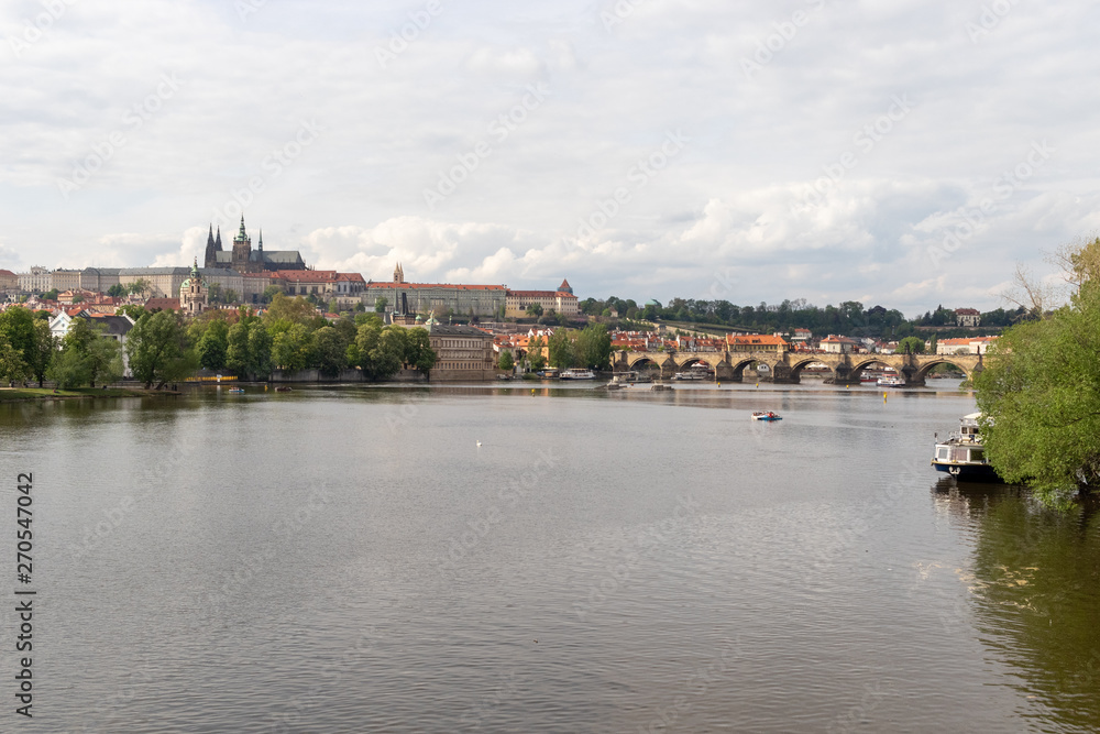 Spring view of Vltava river, swans, boats and city view of Prague / Prague, Czech Republic, May 2019