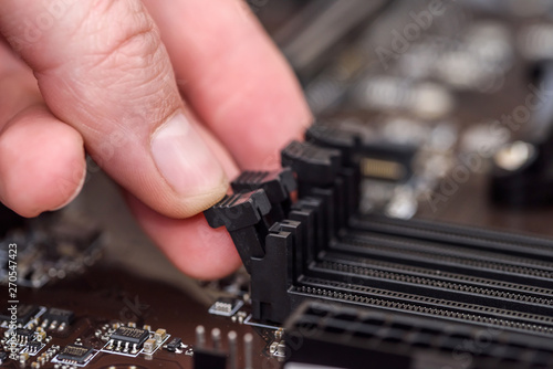 Male hand taking out ram memory on motherboard © RomanR