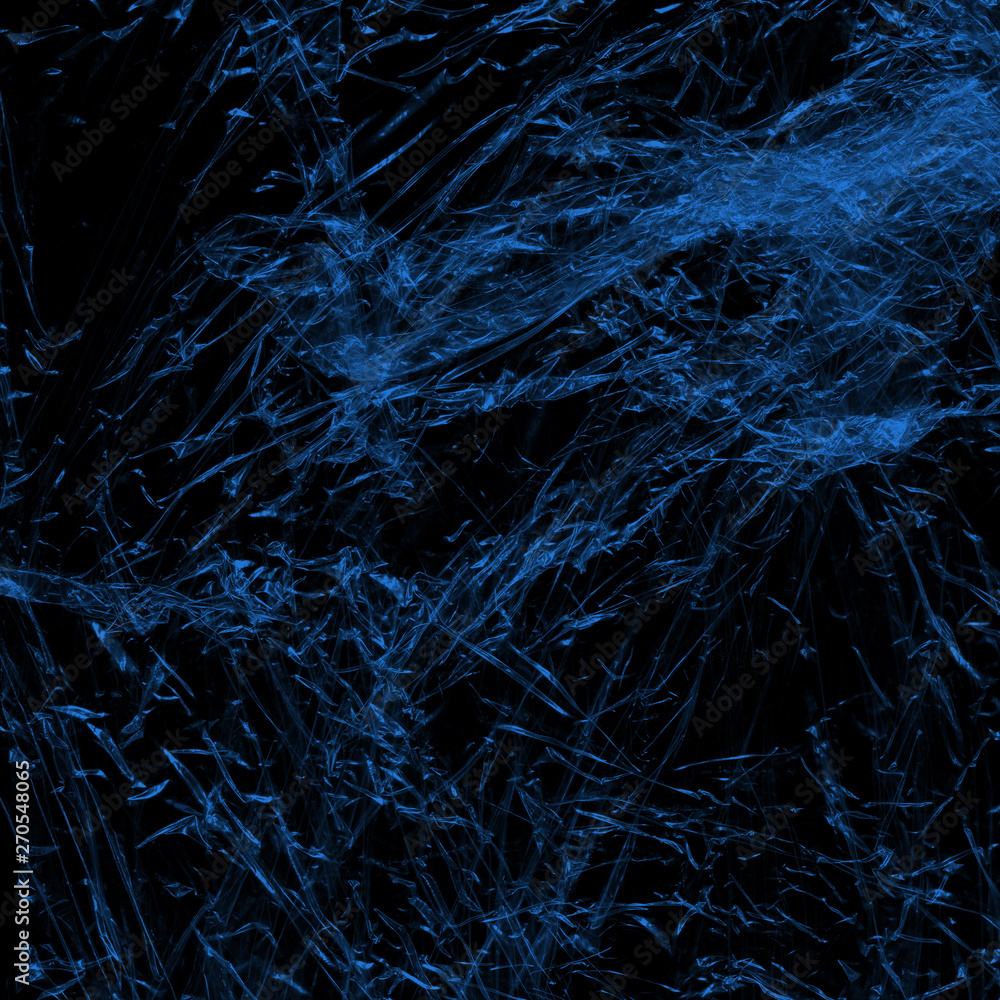 Transparent blue plastic wrap on the black background. Plastic shopping bag texture. Reusable trash and waste. Transparent blue plastic wrap on the black background. Plastic shopping bag texture. Reusable trash and waste.