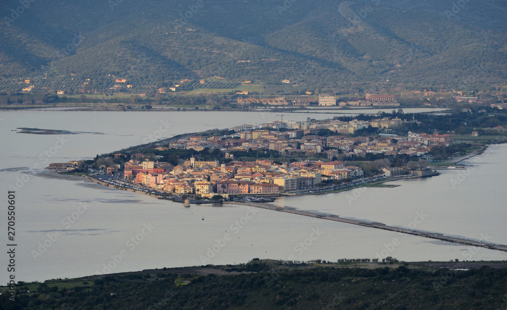 Aerial view of the Orbetello lagoon with the city located on the small peninsula in the middle of the lake, during sunset