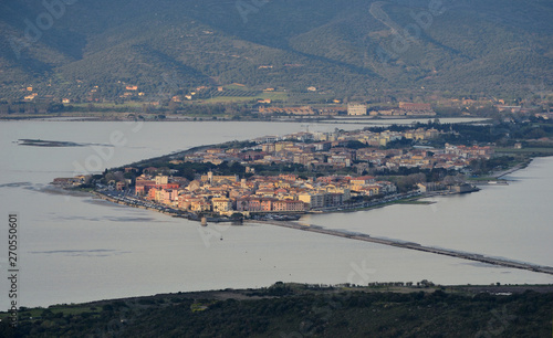 Aerial view of the Orbetello lagoon with the city located on the small peninsula in the middle of the lake, during sunset