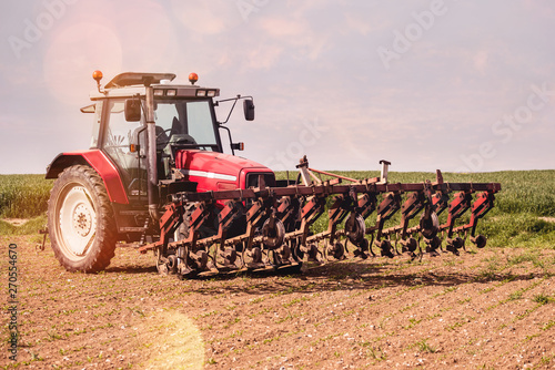 agriculteur passant la herse dans ses champs