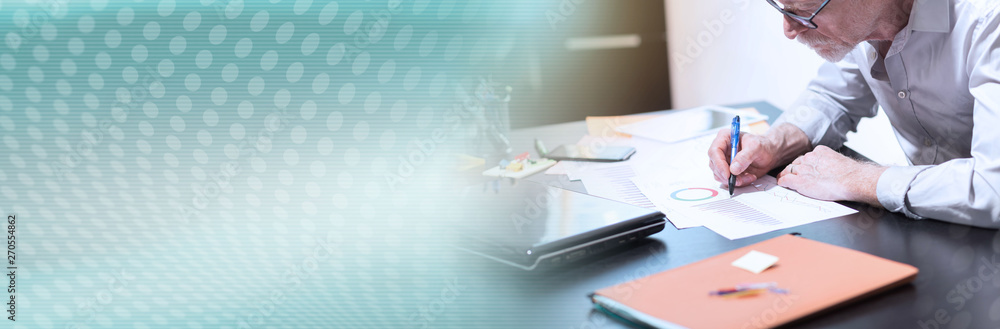 Senior businessman working on business report, light effect; panoramic banner Senior businessman working on business report, light effect; panoramic banner