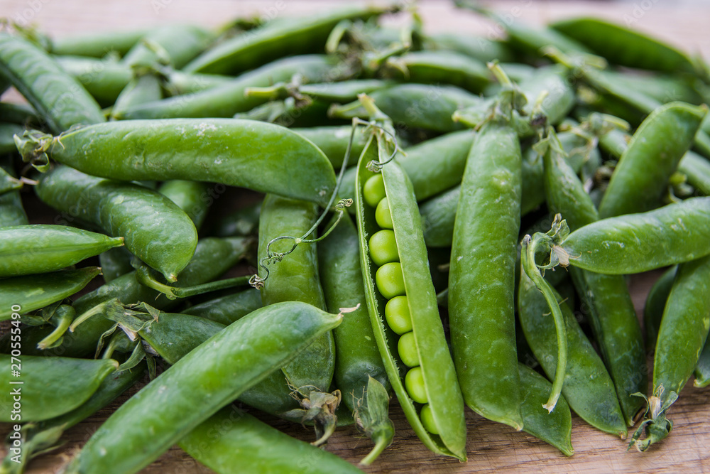 green pea pods on wooden background green pea pods on wooden background