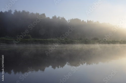 Photo of fog over the pond in the early summer morning