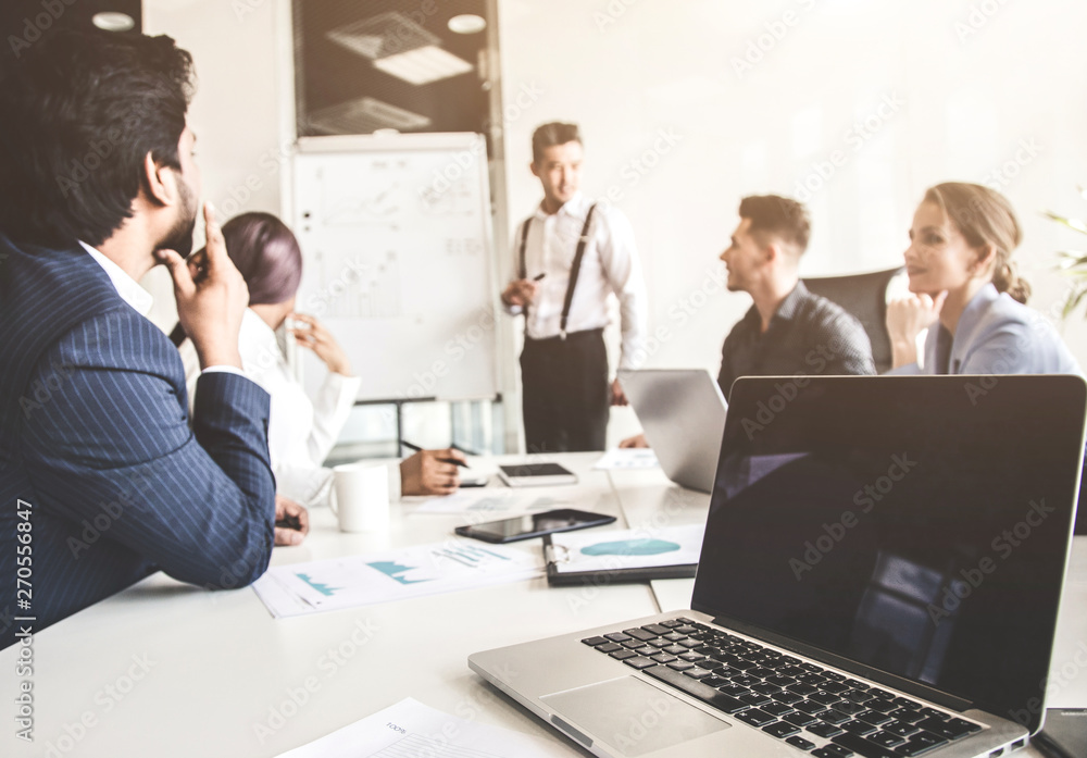 A team of young businessmen working and communicating together in an office. Corporate businessteam and manager in a meeting. A team of young businessmen working and communicating together in an office. Corporate businessteam and manager in a meeting.