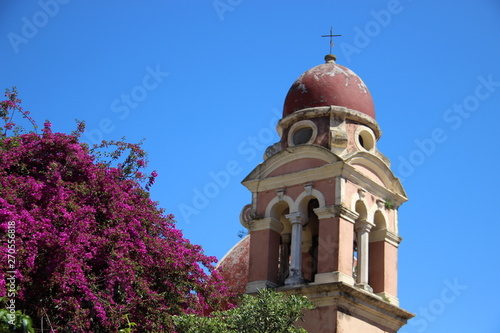 Ancient Church And Bell Tower With Flowering Blossming Purple Bougainvillea  In Summer On Corfu Island Greece photo