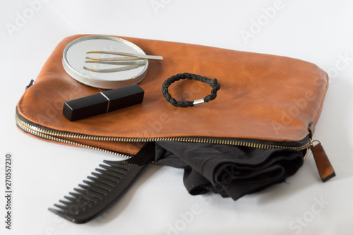 Brown  leather toilet bag with comb, lip stick, underwear and tweezers