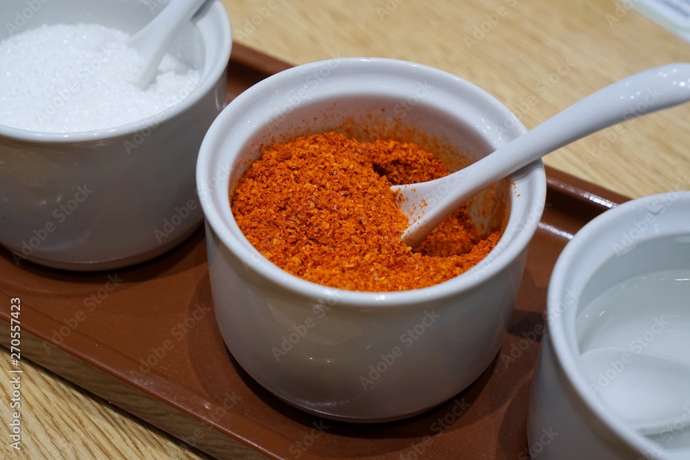 Selective focus of cayenne pepper is seasoning container set for noodle on wooden table in restaurant, Thai food style, Soft focus Selective focus of cayenne pepper is seasoning container set for noodle on wooden table in restaurant, Thai food style, Soft focus
