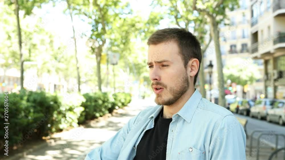 Portrait of an asmathic man using asthma inhaler relieving symptoms in the street Portrait of an asmathic man using asthma inhaler relieving symptoms in the street