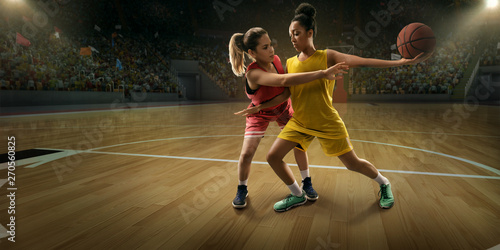 Female basketball players fight for the ball. Basketball players on big professional arena during the game